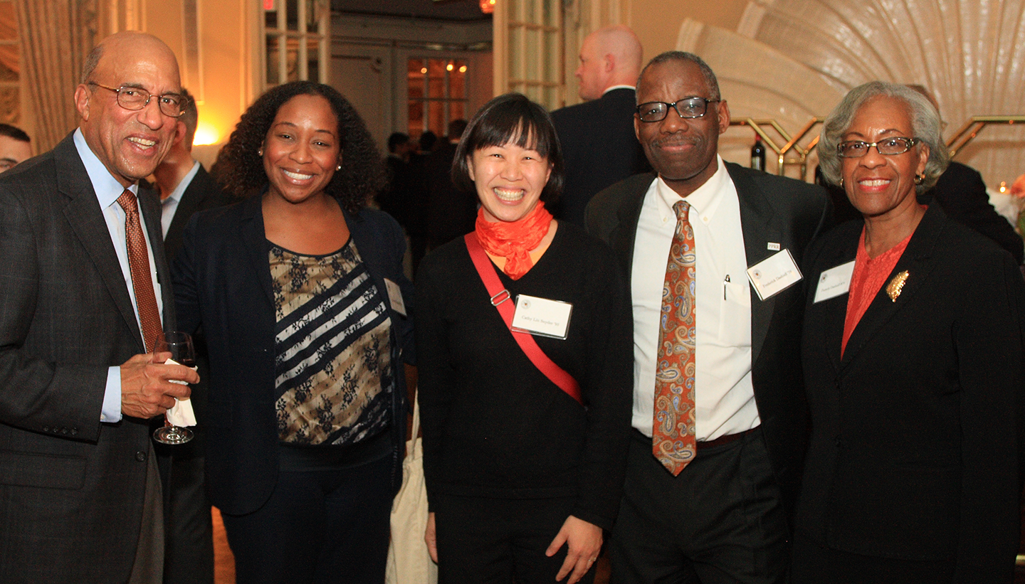 Four alumni posing at a regional event. 