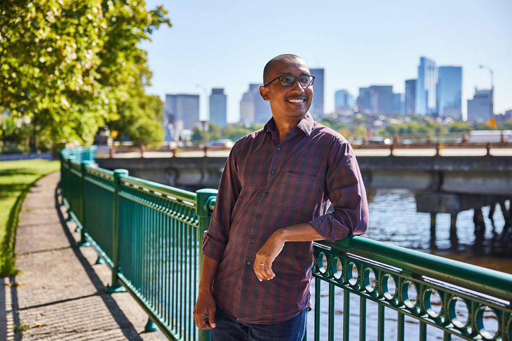 Lester Mackey, leaning on a railing overlooking a body of water